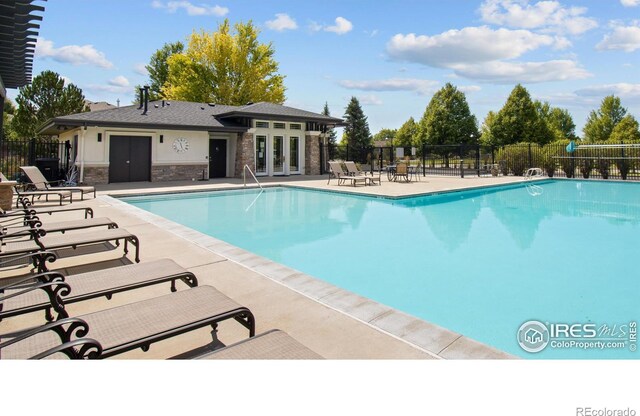 community pool featuring a patio and fence