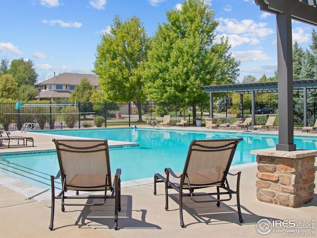 community pool featuring fence and a pergola