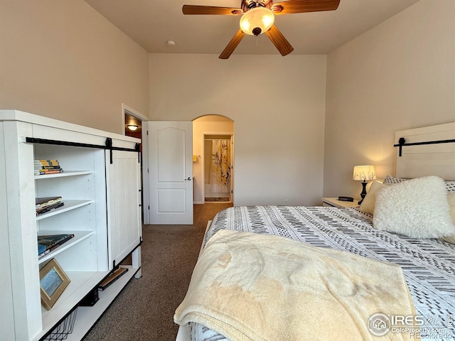 4645 Hahns Peak Dr Unit 201, Loveland, CO 80538 - bedroom featuring dark colored carpet, arched walkways, a barn door, and ceiling fan