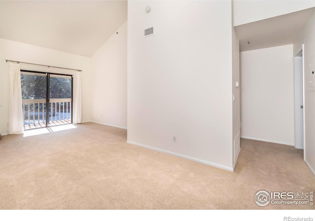 empty room with light carpet, high vaulted ceiling, visible vents, and baseboards