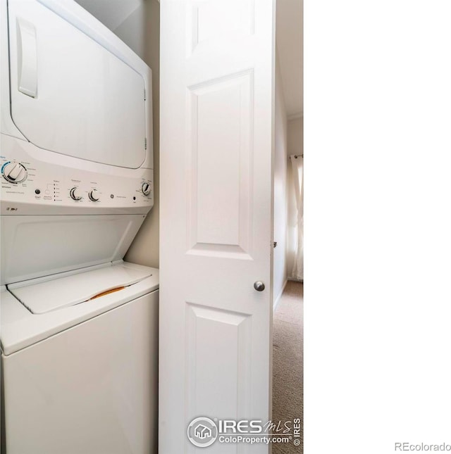 clothes washing area featuring laundry area, carpet, and stacked washer / drying machine