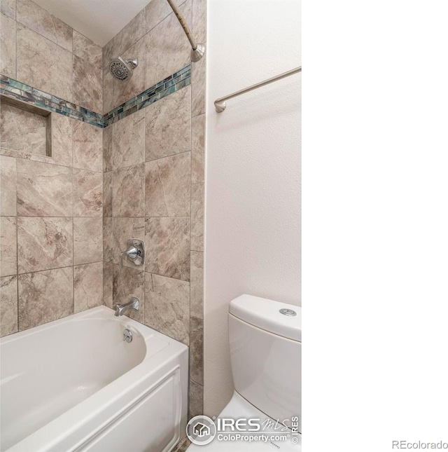 bathroom with washtub / shower combination and toilet