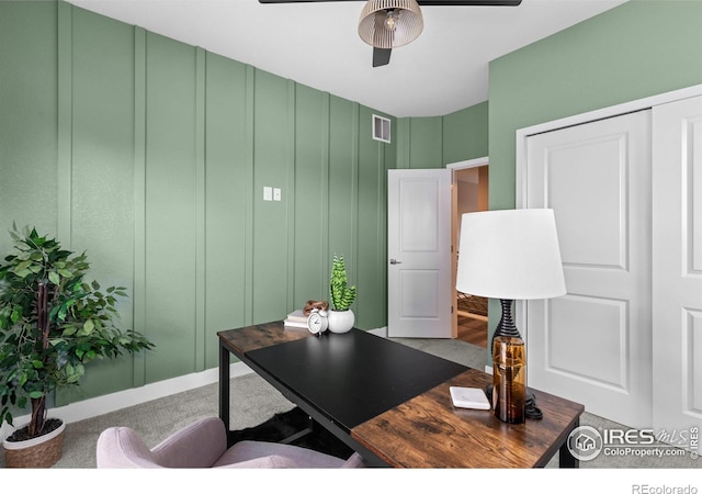 office space featuring ceiling fan, visible vents, and a decorative wall