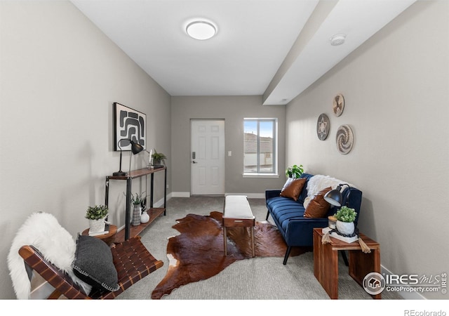 carpeted living area featuring baseboards