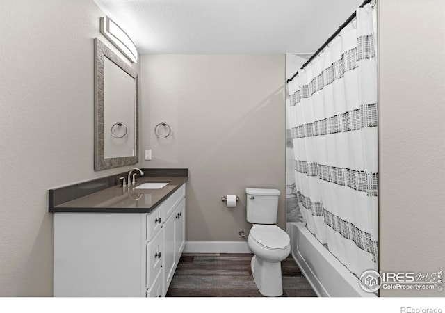 full bath with baseboards, toilet, wood finished floors, shower / tub combo with curtain, and vanity