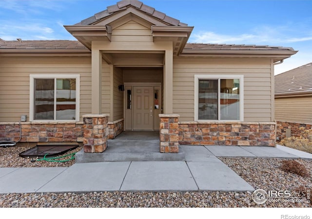 view of exterior entry featuring stone siding