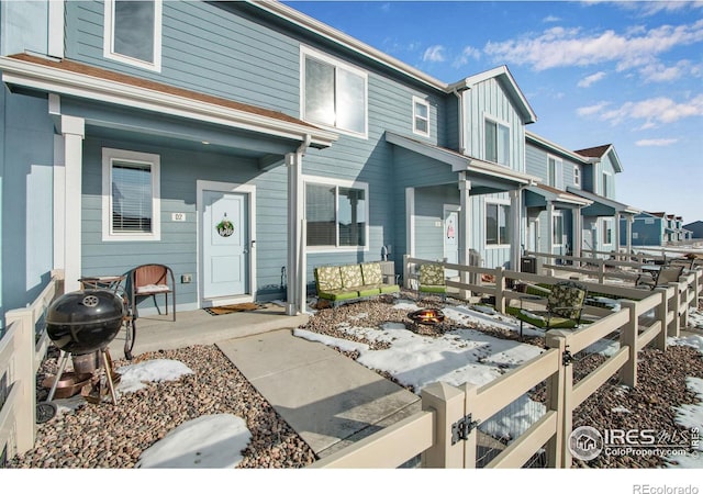 view of front facade featuring a fire pit, board and batten siding, and fence private yard