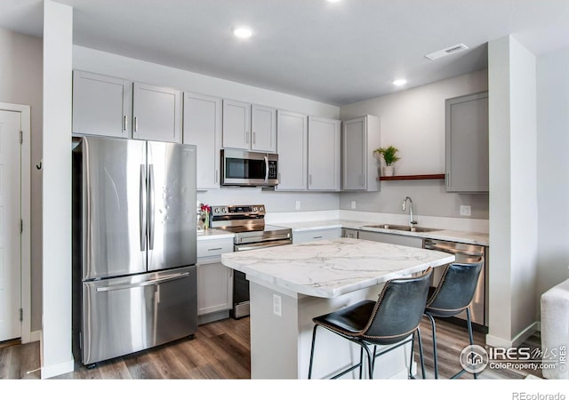 kitchen with dark wood-style flooring, a center island, stainless steel appliances, open shelves, and a sink