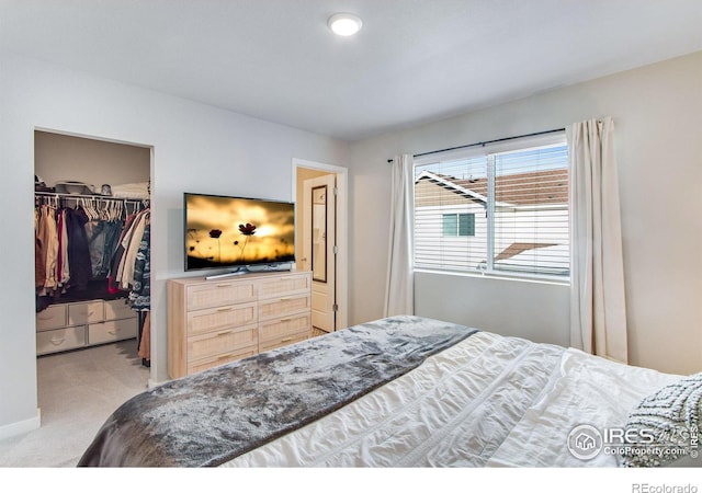 bedroom featuring light carpet, a closet, and a walk in closet