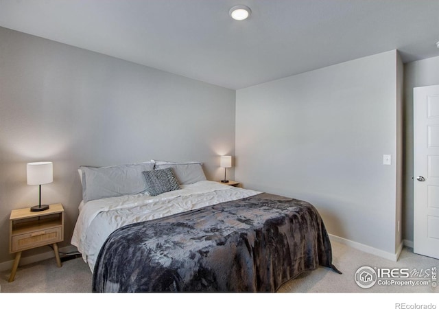 bedroom featuring light colored carpet and baseboards