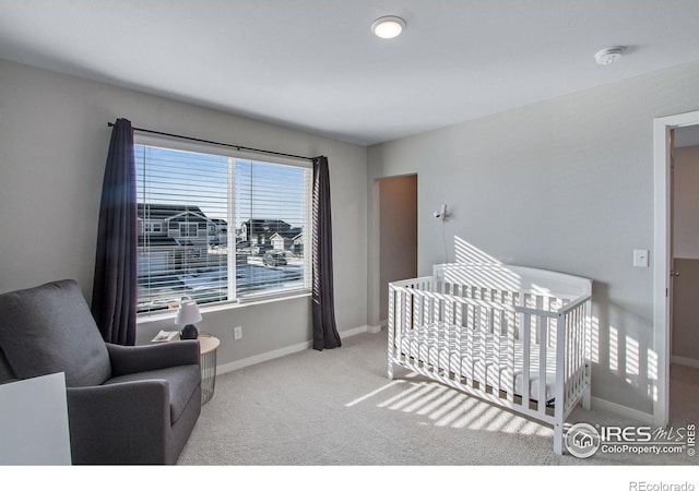 bedroom featuring light carpet, a nursery area, and baseboards