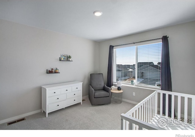 bedroom with a nursery area, light carpet, visible vents, and baseboards