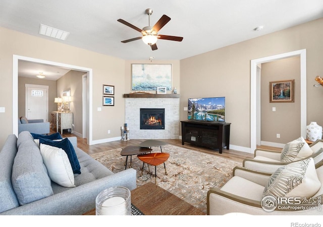 living area featuring visible vents, baseboards, and wood finished floors