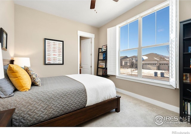 bedroom featuring light colored carpet, ceiling fan, and baseboards