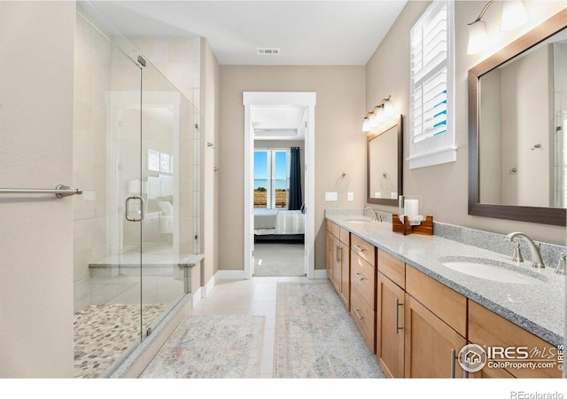 ensuite bathroom featuring a stall shower, double vanity, a sink, and ensuite bathroom