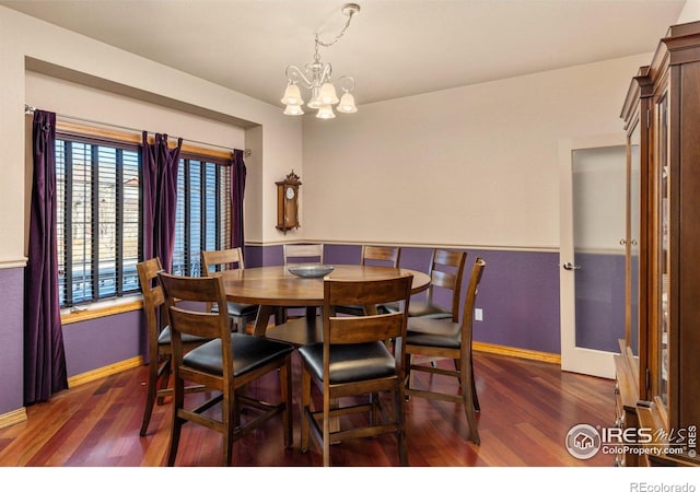 dining area with dark wood-style floors, baseboards, and a chandelier