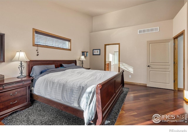 bedroom featuring dark wood-style floors, baseboards, and visible vents