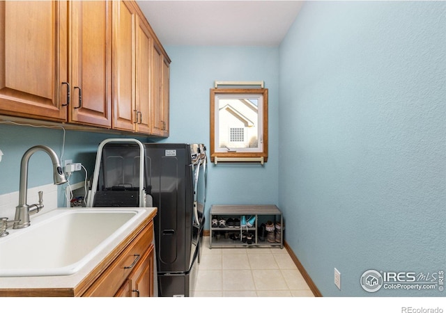 laundry room with washer hookup, light tile patterned floors, cabinet space, a sink, and baseboards