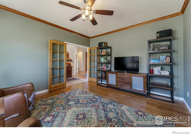 living area featuring baseboards, a ceiling fan, ornamental molding, wood finished floors, and french doors