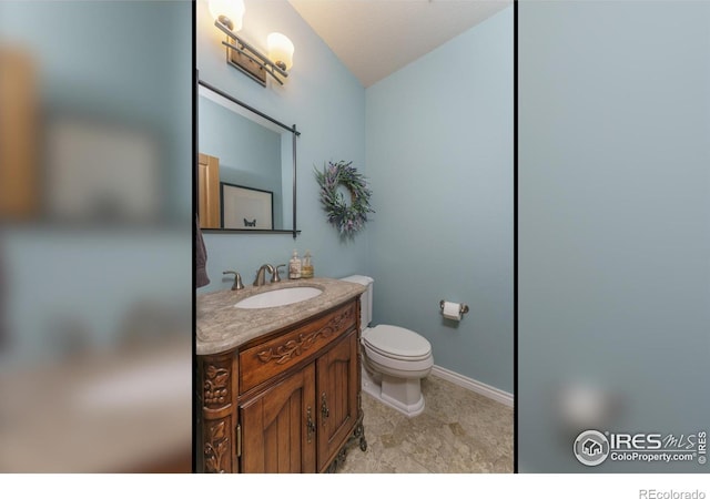 bathroom with vanity, toilet, and baseboards