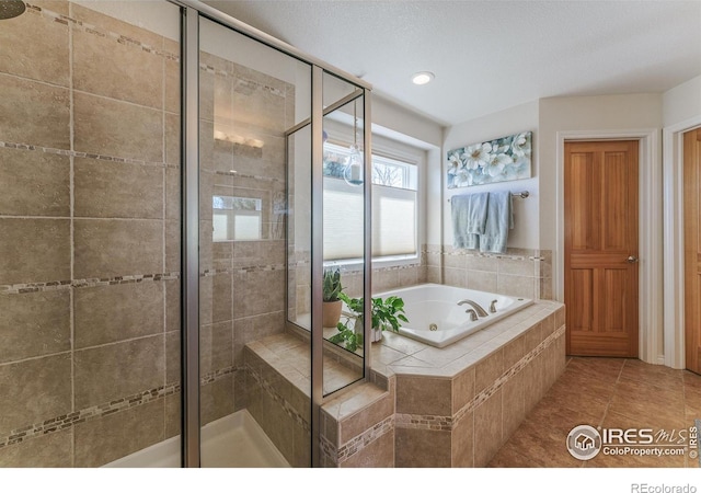 bathroom featuring a garden tub, a shower stall, and tile patterned floors