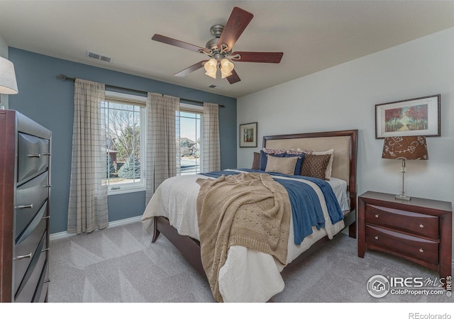 bedroom featuring ceiling fan, visible vents, baseboards, and light colored carpet