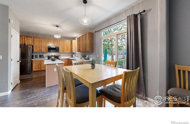 dining area with dark wood-type flooring and baseboards