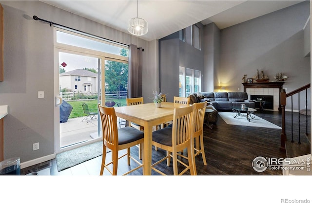 dining room with a fireplace, baseboards, and wood finished floors