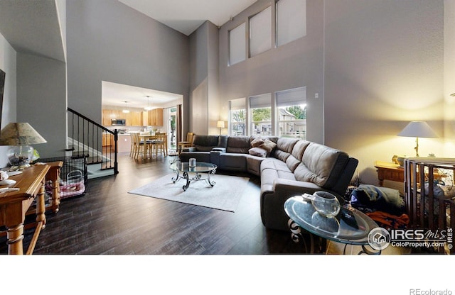 living area featuring dark wood-type flooring and stairway