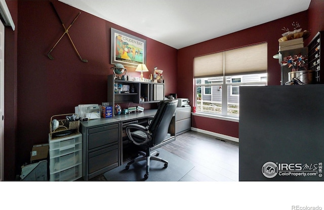 office featuring baseboards, visible vents, and wood finished floors