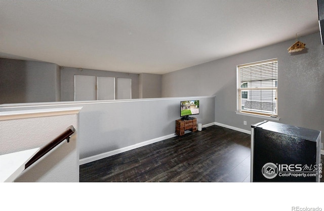 interior space featuring dark wood-style flooring and baseboards