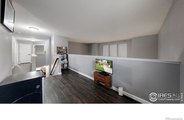 interior space featuring baseboards and dark wood-type flooring