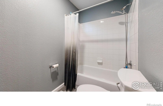 bathroom with a textured wall and toilet