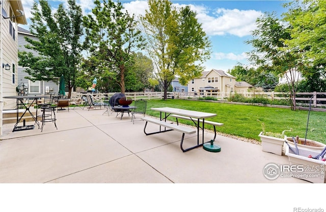 view of property's community featuring a patio area, fence, and a lawn