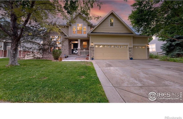 craftsman inspired home featuring covered porch, an attached garage, a front yard, stone siding, and driveway