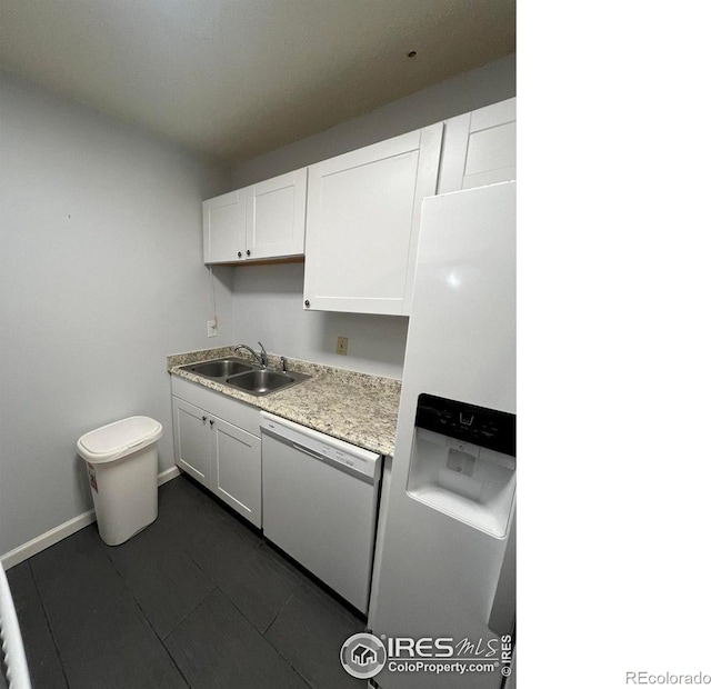 kitchen with white appliances, white cabinets, a sink, and light countertops