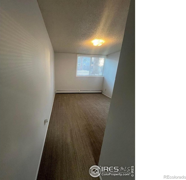 carpeted spare room featuring baseboards, baseboard heating, and a textured ceiling