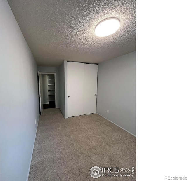 2707 Valmont Rd Unit 111A, Boulder, CO 80304 - unfurnished bedroom featuring a textured ceiling, carpet, and a closet