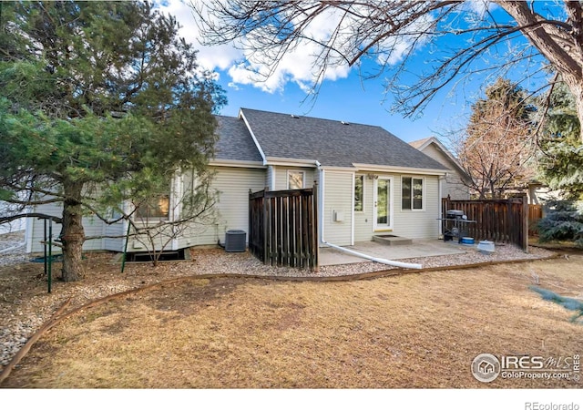 back of property featuring roof with shingles, a patio area, fence, and cooling unit