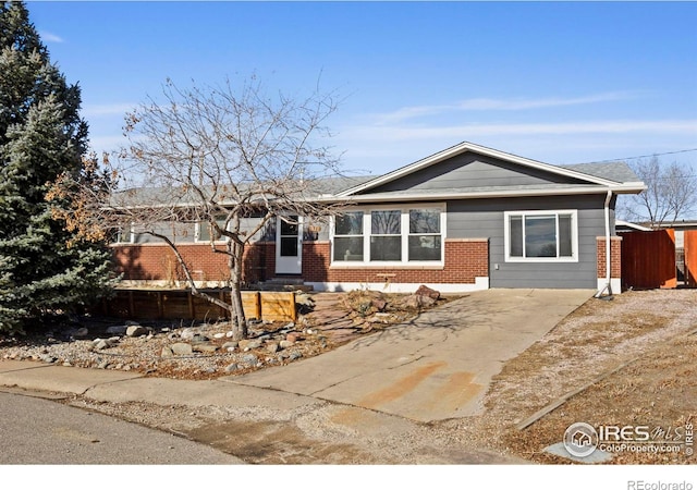 ranch-style house featuring brick siding and fence