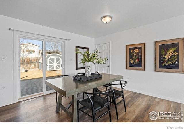 dining area featuring baseboards and dark wood finished floors