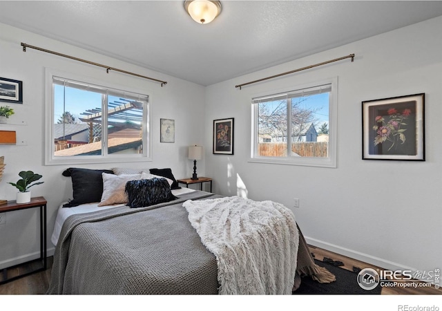 bedroom featuring wood finished floors and baseboards