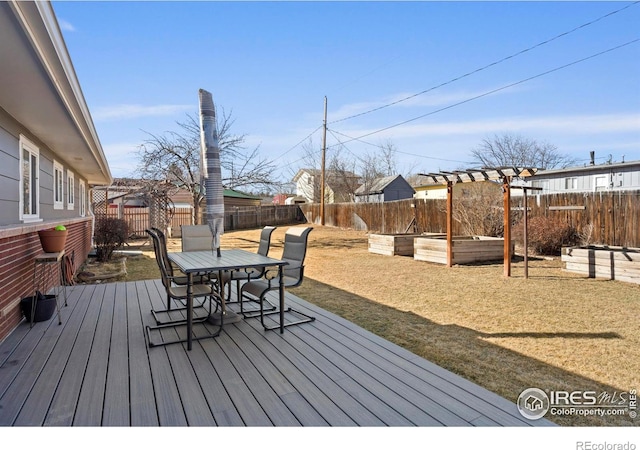 wooden deck with outdoor dining space, a garden, and a fenced backyard