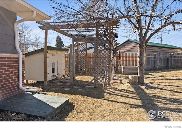 view of yard with fence and an outdoor structure