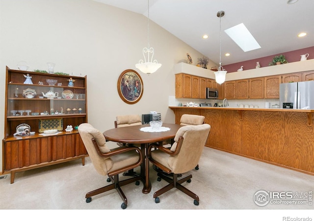 dining room featuring a skylight, recessed lighting, high vaulted ceiling, and light colored carpet