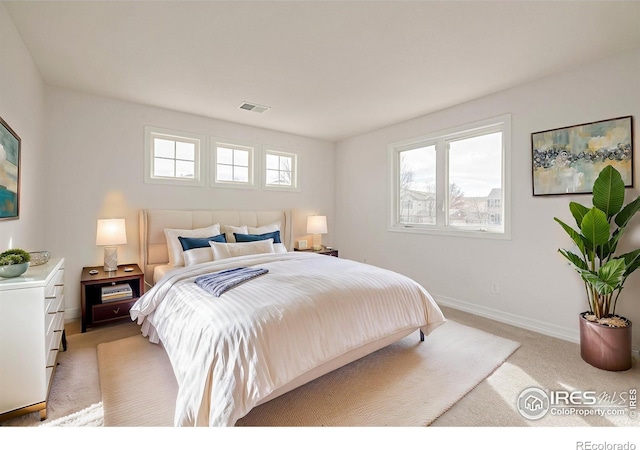 bedroom featuring light colored carpet, visible vents, and baseboards