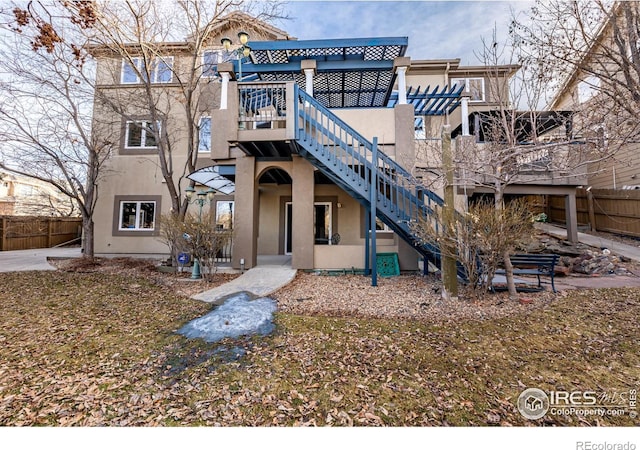 back of property featuring stairs, a patio area, fence, and stucco siding