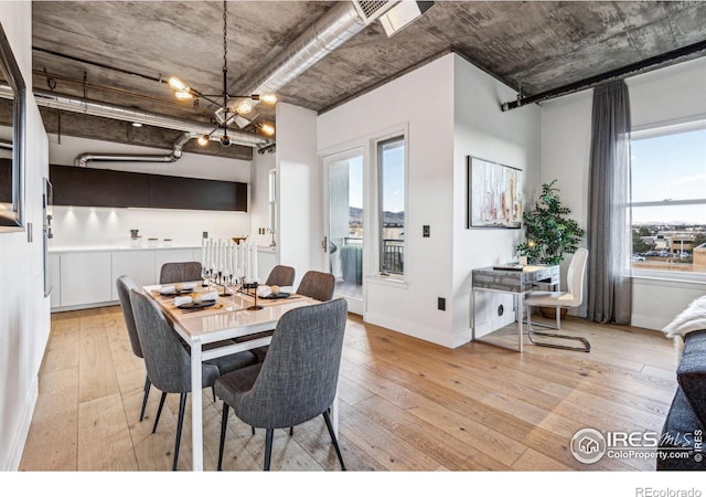 dining room with baseboards, light wood-style flooring, and an inviting chandelier