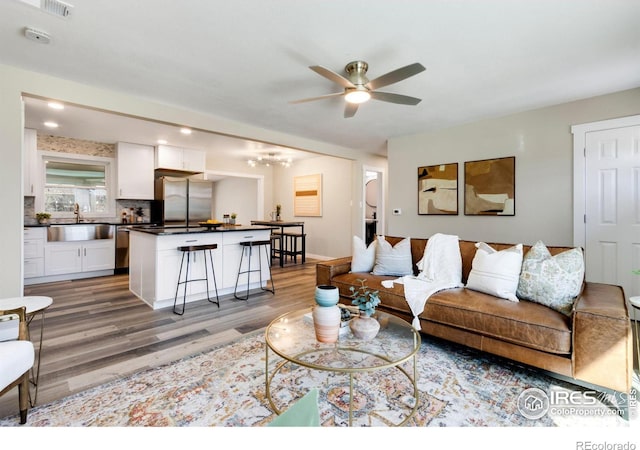 living area with ceiling fan and light wood-style flooring