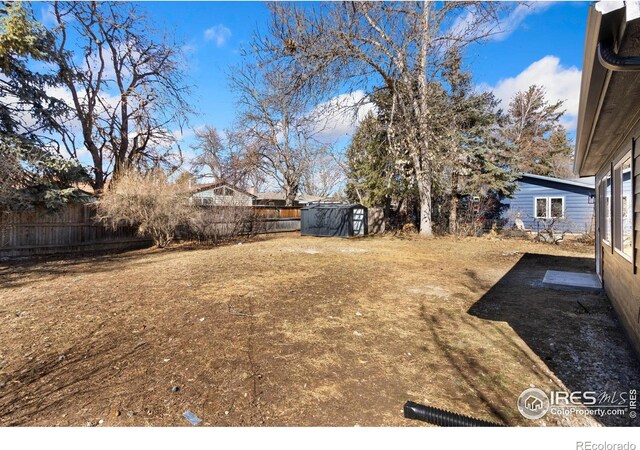 view of yard featuring an outbuilding, a shed, and a fenced backyard